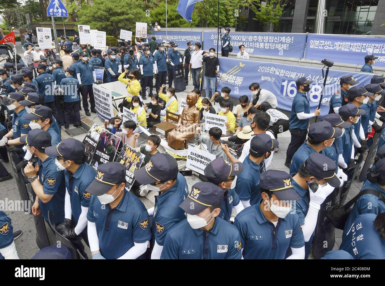 Séoul, Corée du Sud. 23 juin 2020. Les jeunes manifestants qui se rassemblent autour d'une statue symbolisant la question des « femmes de confort », qui ont travaillé dans les maisons closes de l'armée japonaise pendant la guerre, insistent le 23 juin 2020 pour qu'elles continuent à organiser des rassemblements chaque mercredi devant l'ambassade japonaise à Séoul. Les policiers se tiennent autour d'eux. (Kyodo)==Kyodo photo via crédit: Newscom/Alay Live News Banque D'Images