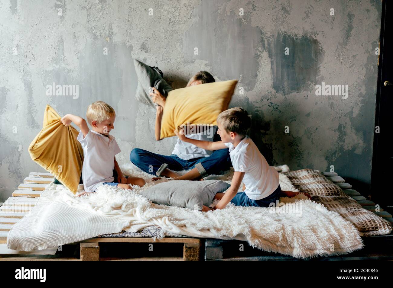 Famille jouant. Maman et fils blague et combat des oreillers. Ventilateur familial. Banque D'Images