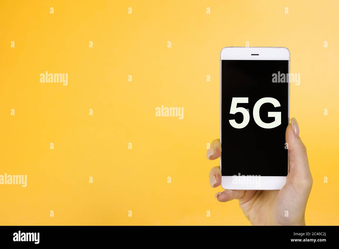 Arrière-plan créatif, main tenant un téléphone avec un symbole 5G. Le concept de réseau 5G, Internet mobile haut débit, réseaux de nouvelle génération Banque D'Images