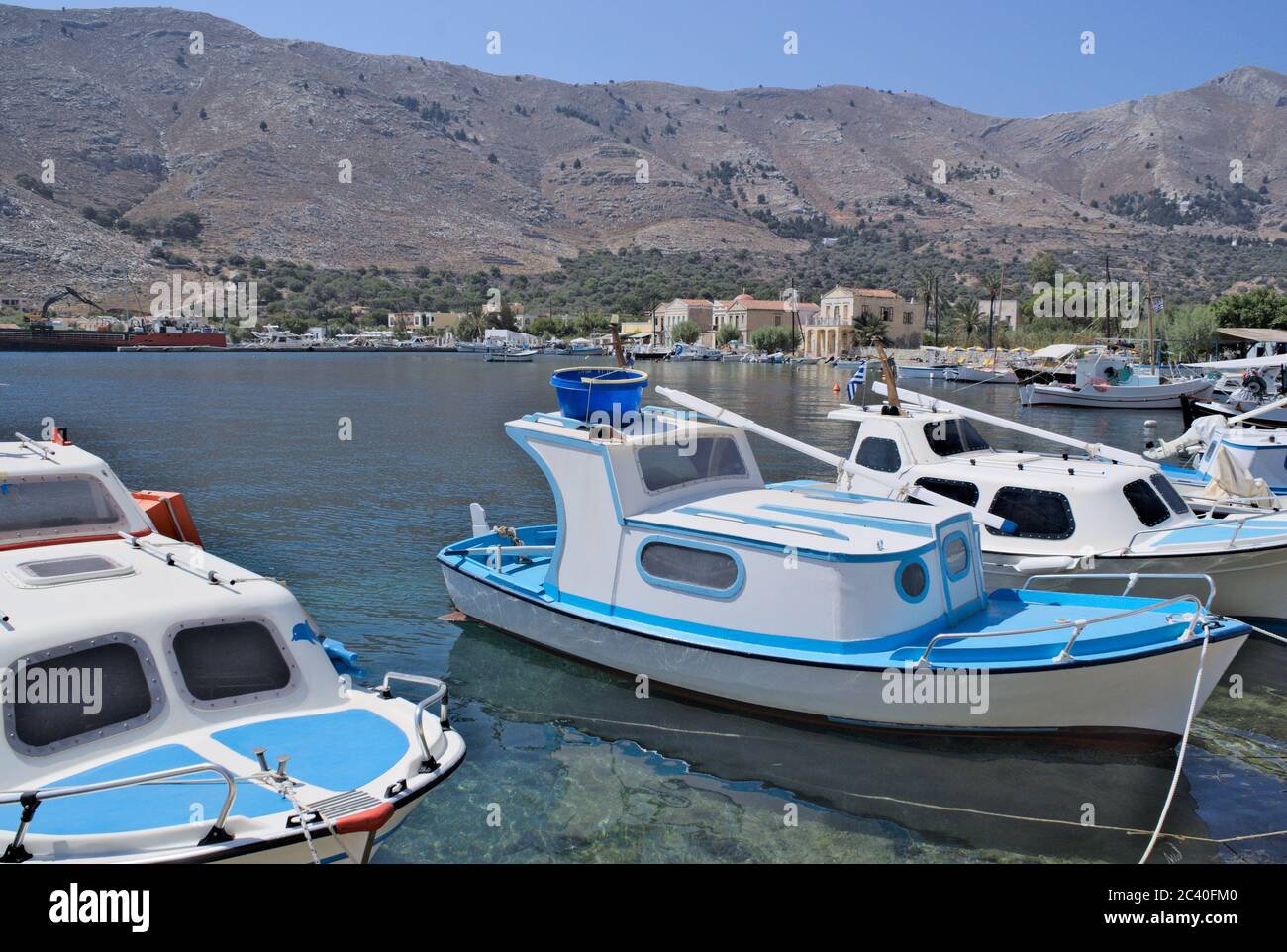 De petits bateaux de pêche amarrés au petit port de Pedi sur la belle île grecque de Symi. Banque D'Images