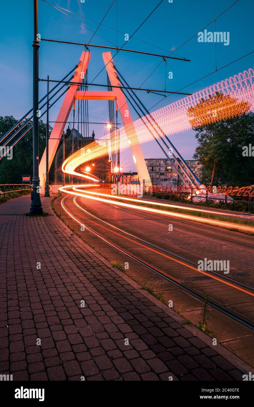 Trafic ferroviaire de nuit sur le pont Wladyslaw Jagiello à Bydgoszcz. Paysage de la ville de Niht. Exposition longue. Banque D'Images