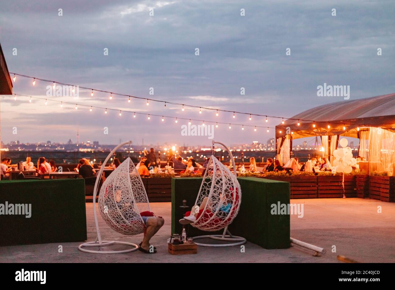 personnes assistant à une fête d'été en plein air sur le toit en soirée Banque D'Images