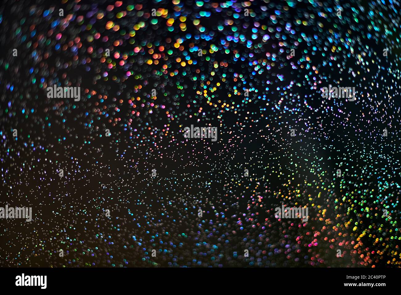 Arc-en-ciel scintillant. Toile de fond abstraite. Des gouttes et des lumières arc-en-ciel colorées et brillantes sur fond noir. Paillettes brillantes festives de paillettes floues et Banque D'Images