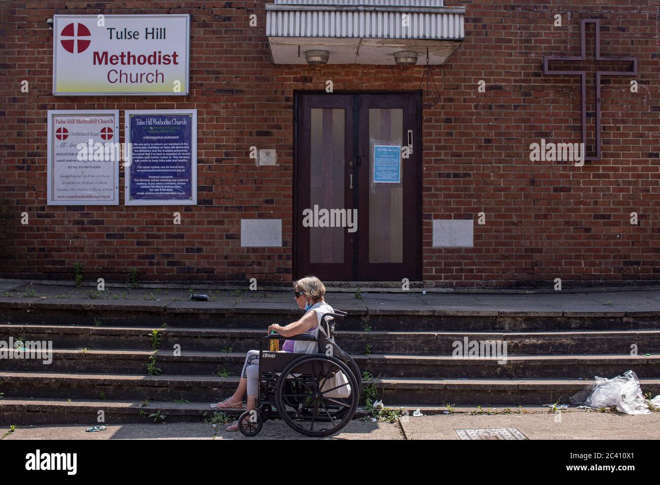 Londres, Angleterre. 23 juin 2020. Une dame âgée en fauteuil roulant tenant une grande capacité d'attente devant l'église méthodiste Tulse Hill dans le sud de Londres, en Angleterre. (Photo de Sam Mellish / Alamy Live News) Banque D'Images