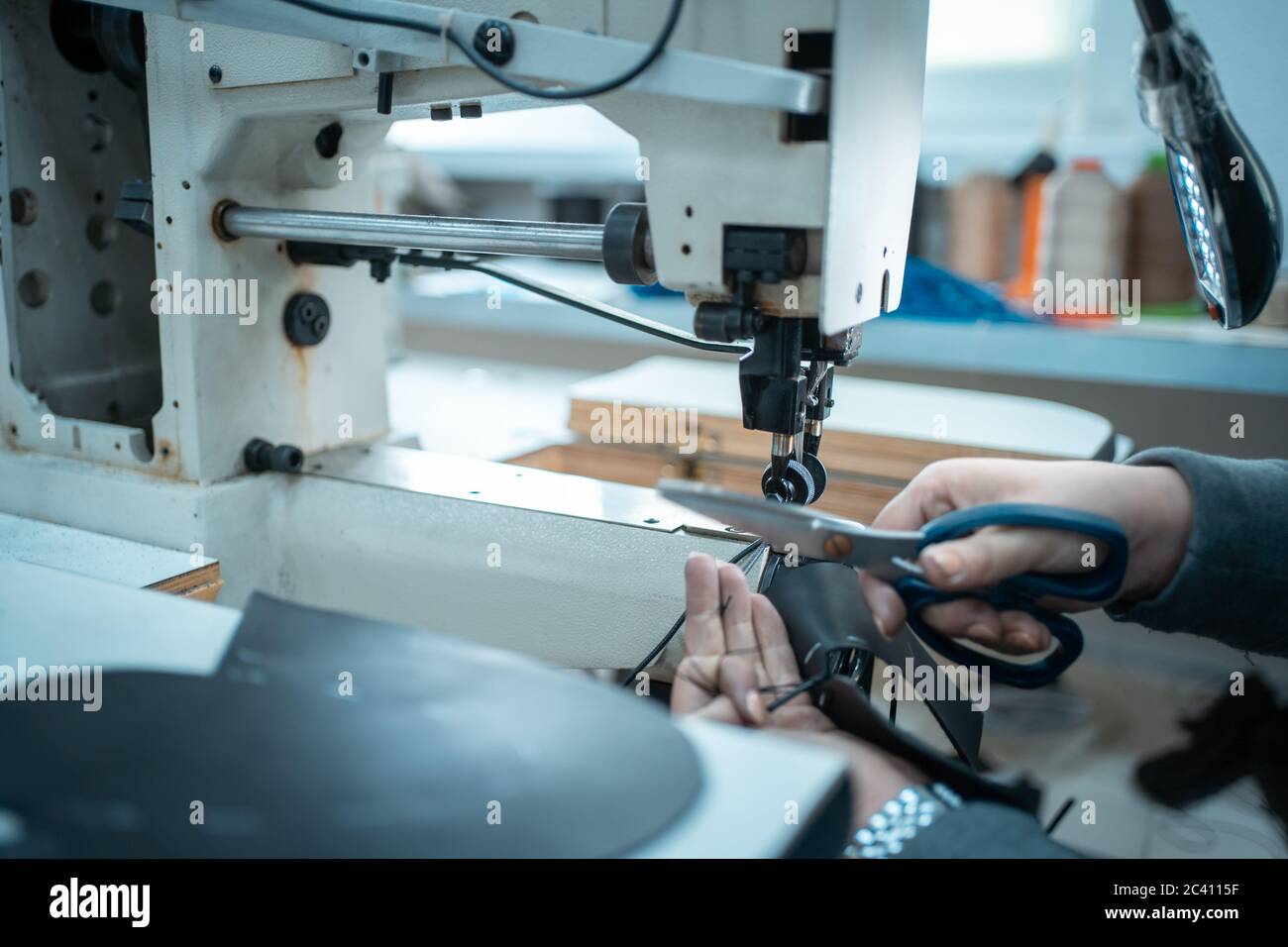 femme travaille avec des machines à coudre sur une usine de chaussures Banque D'Images