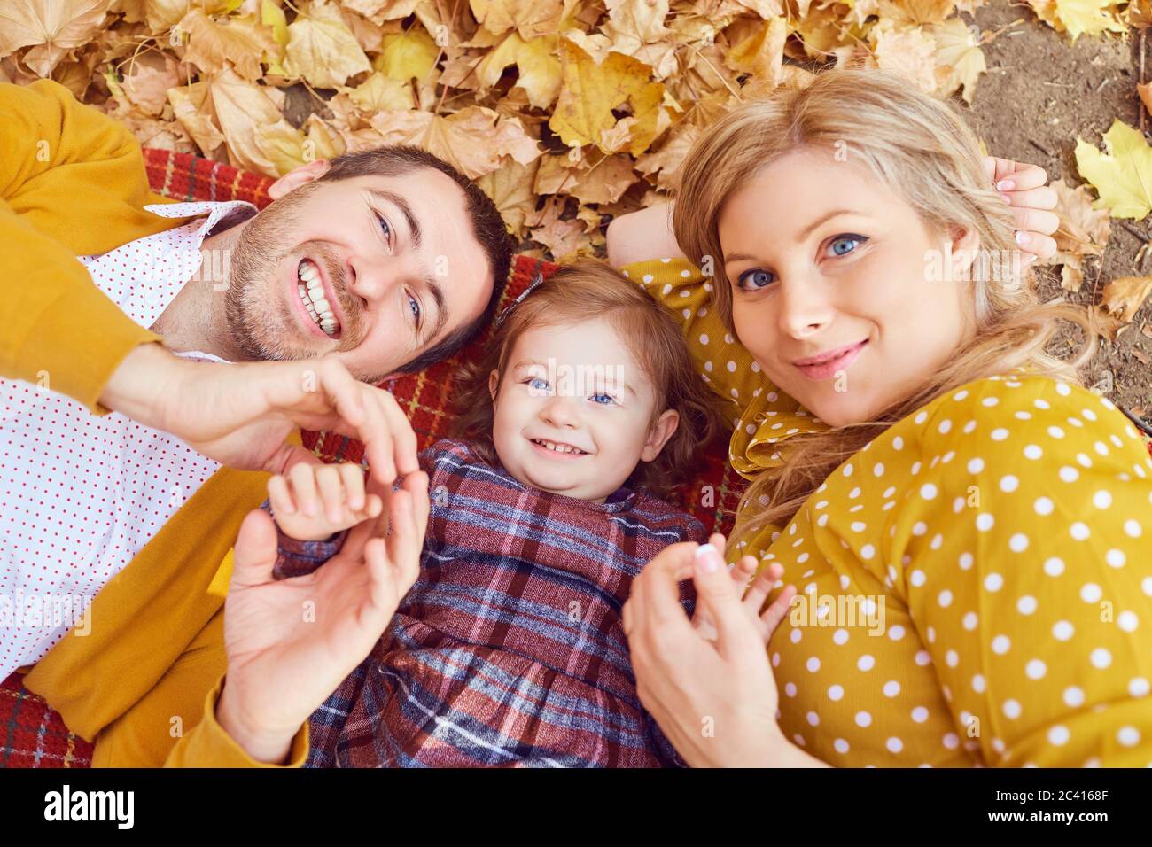 Famille heureuse étendu dans le parc en automne. Banque D'Images