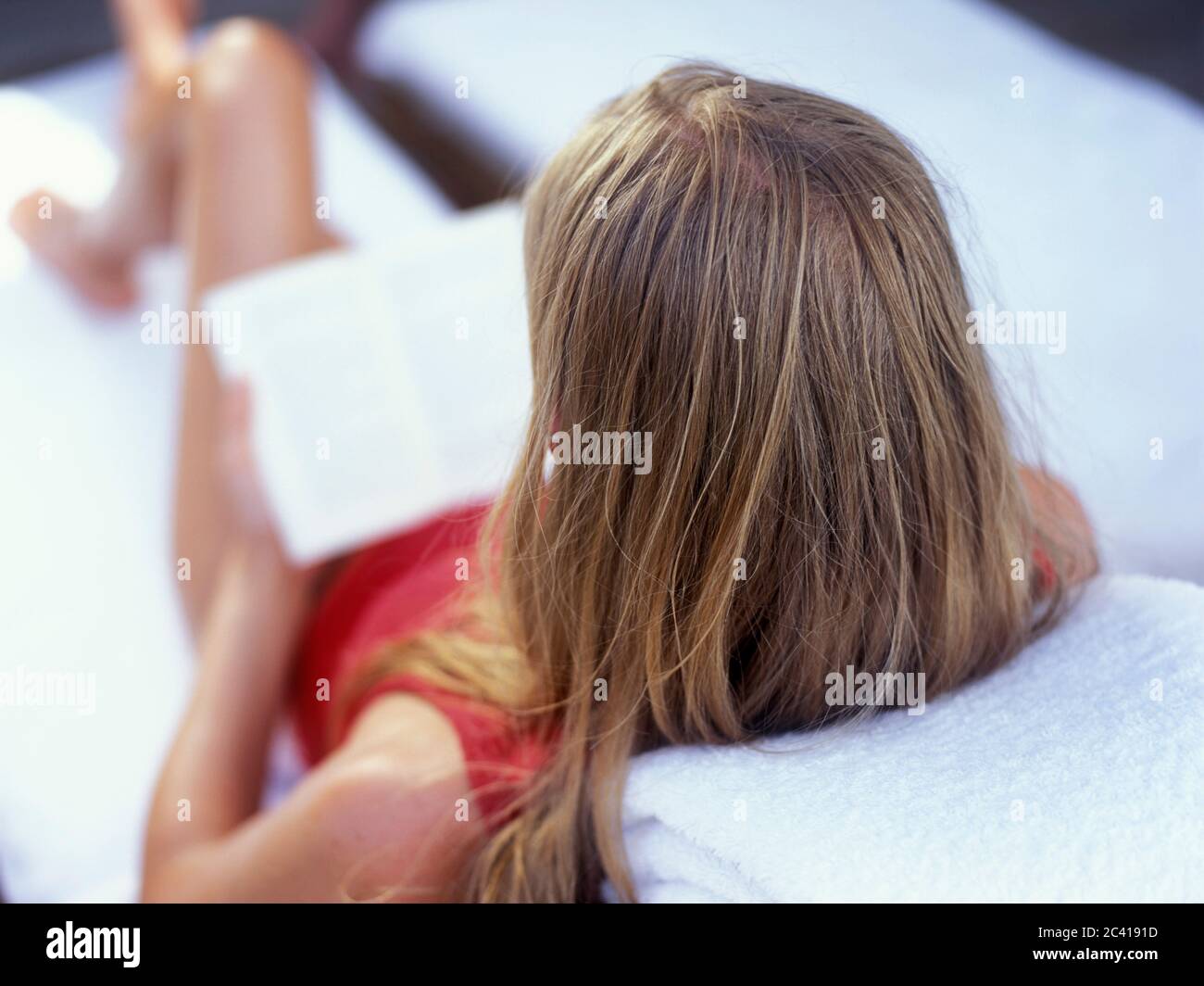 Jeune femme blonde lit le livre sur la chaise de pont - détente - vacances Banque D'Images