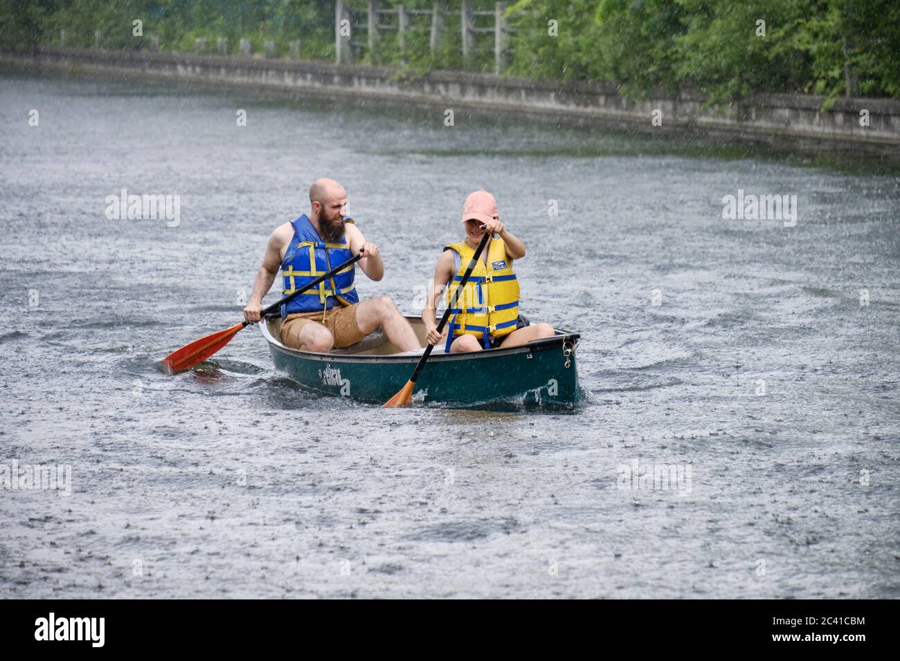 Un jeune couple aviron rapidement pour se loger car il a été pris en canoë dans le canal d'Ottawa quand une tempête violente s'est abattue Banque D'Images