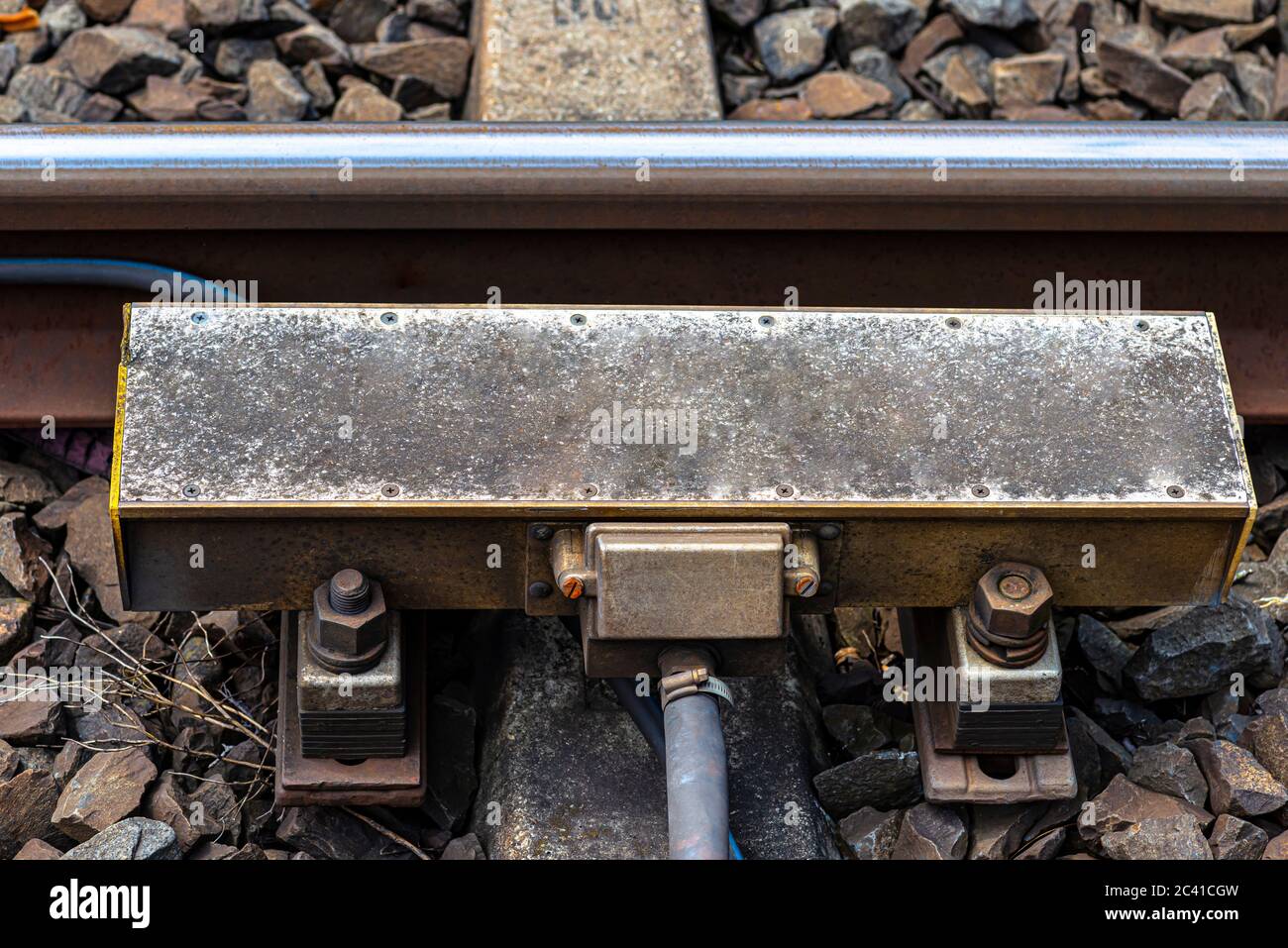 Système de freinage automatique des trains monté sur les voies ferrées, traverses en béton visibles et grandes pierres entre elles. Banque D'Images