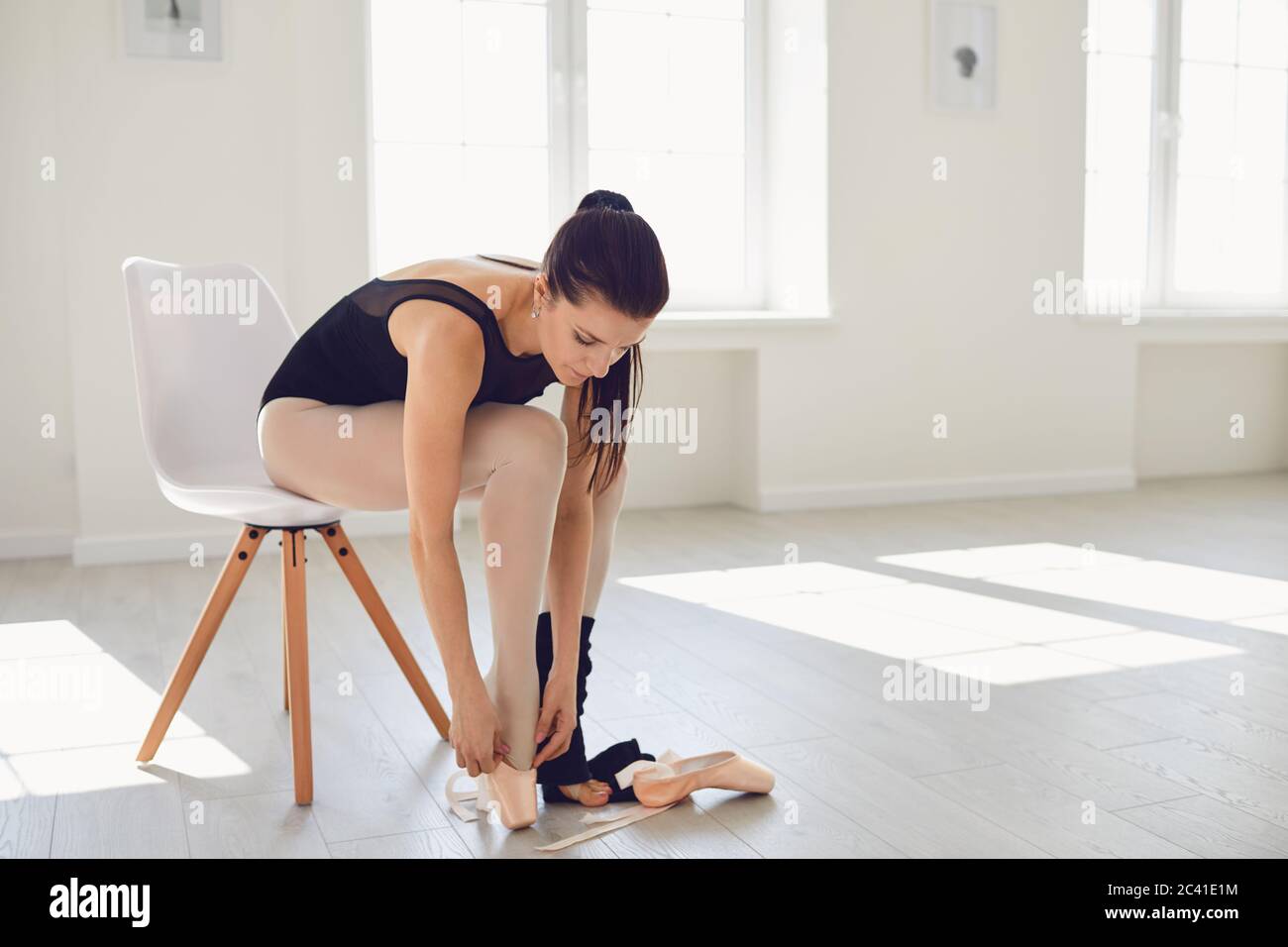 Ballerine de ballet. La ballerine fille habille les chaussures de pointe avant de s'entraîner dans le studio. Banque D'Images