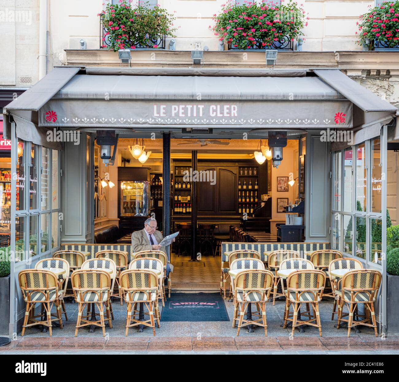Homme lisant des journaux au petit Cler - café sur la rue Cler dans le 7ème arrondissement, Paris, France Banque D'Images