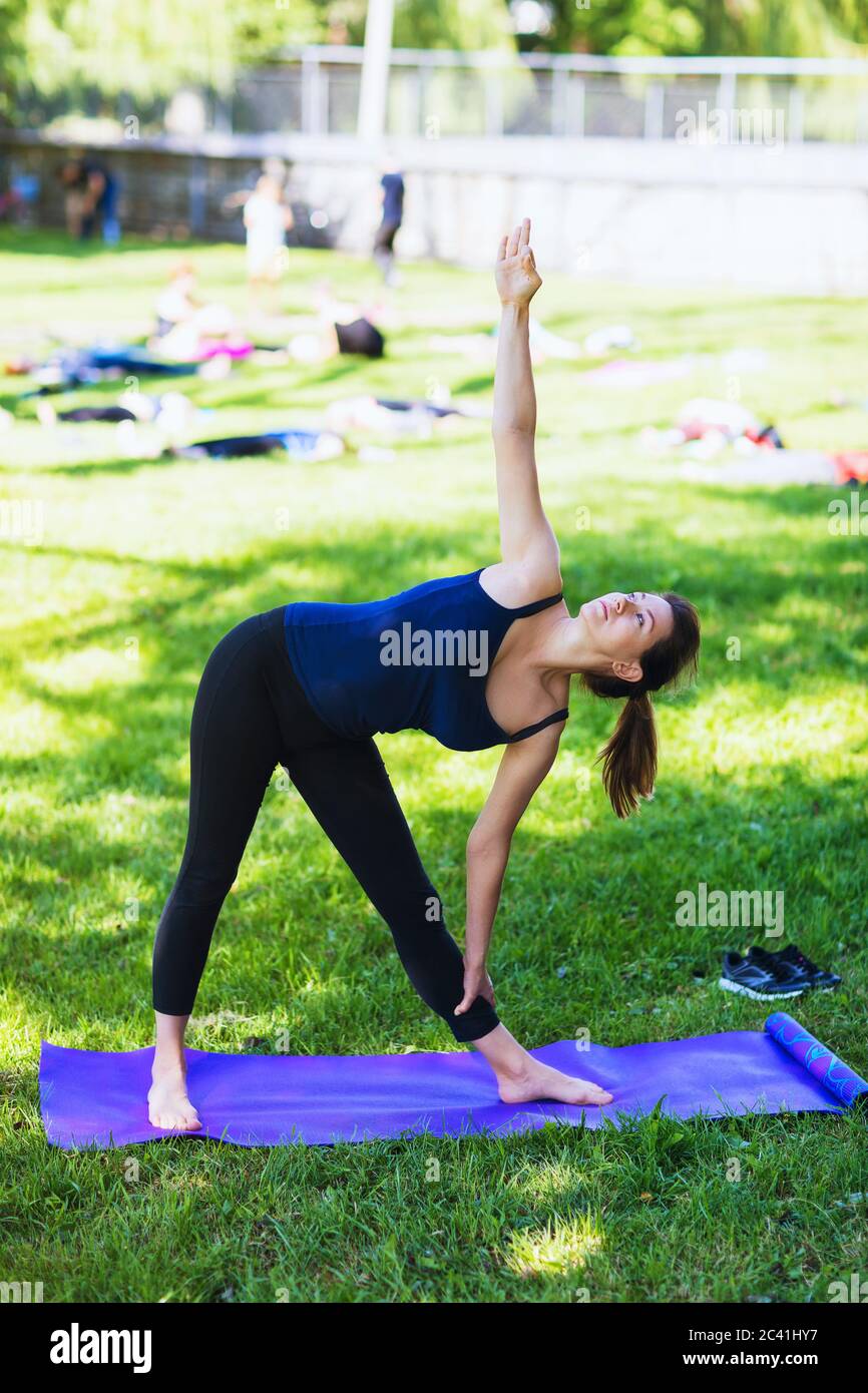 Une fille fait de l'exercice de yoga dans le parc par une belle journée d'été Banque D'Images