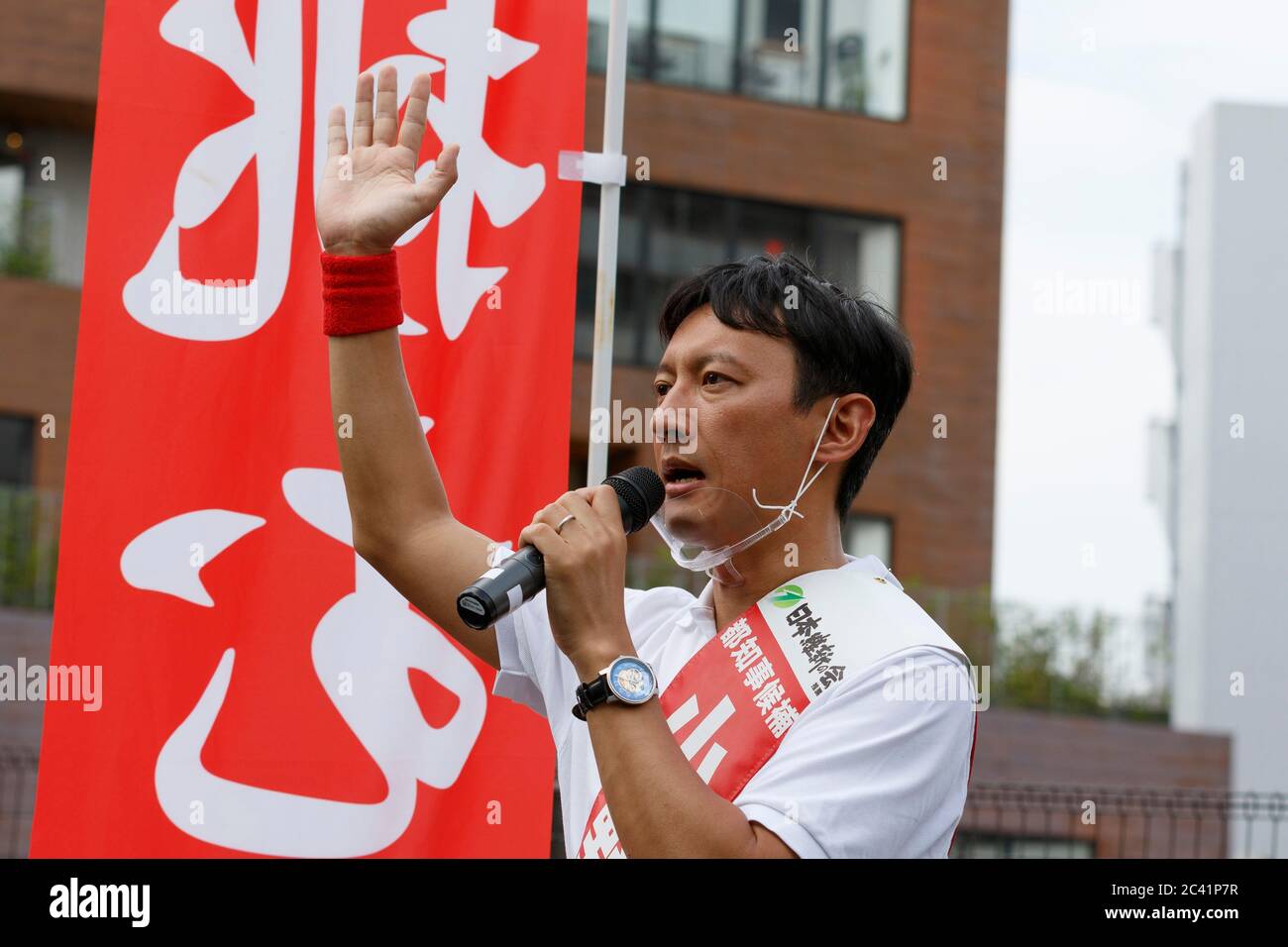 Tokyo, Japon. 23 juin 2020. Le candidat Taisuke Ono porte un bouclier buccal lors de son discours de campagne pour l'élection du gouverneur de Tokyo à l'extérieur de la gare de Shimokitazawa. Ono, ancien vice-gouverneur de la préfecture de Kumamoto, fait campagne pour l'élection du gouverneur de Tokyo, qui aura lieu le 5 juillet. Credit: Rodrigo Reyes Marin/ZUMA Wire/Alay Live News Banque D'Images