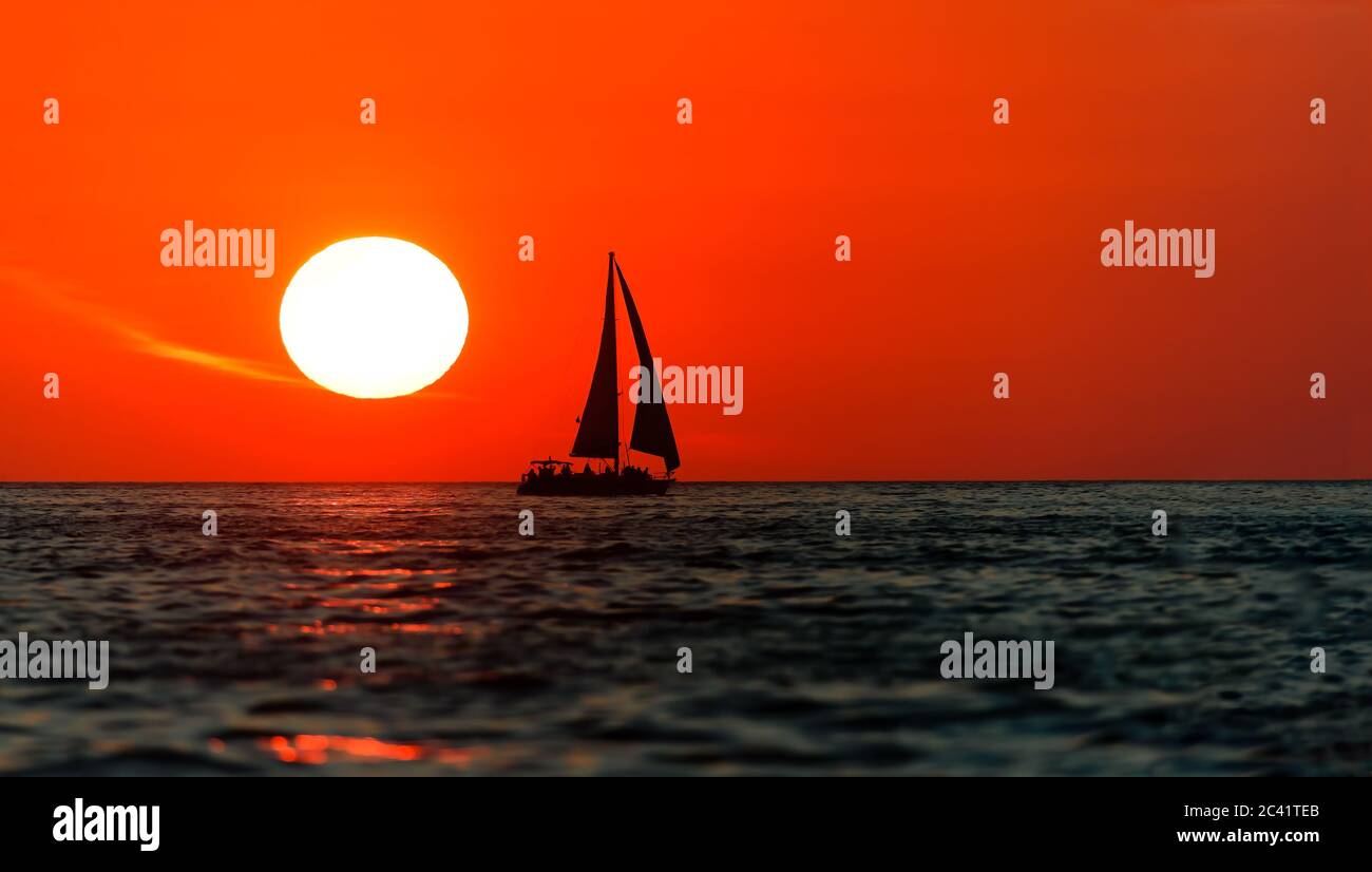 Un Voilier est en voilier avec un coucher de soleil sur l'océan Banque D'Images