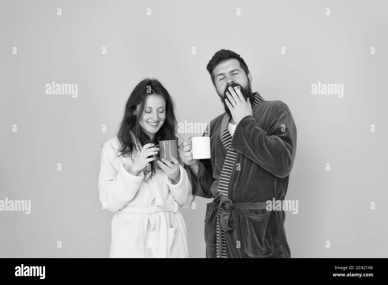 Boire du café. Préparer du café à la maison. Boisson chaude. Ensemble plus savoureux. Le café est notre tradition. Homme et femme heureux ensemble. Traditions familiales. Couple dans des peignoirs confortables profiter du week-end paresseux. Banque D'Images