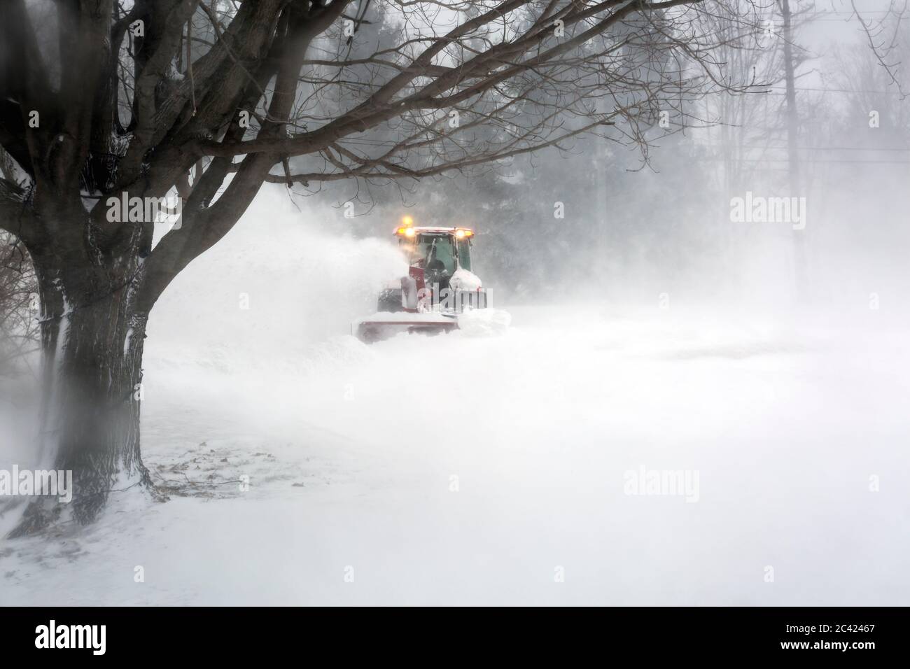 souffleur de neige soufflant de la neige de l'allée pendant le blizzard Banque D'Images