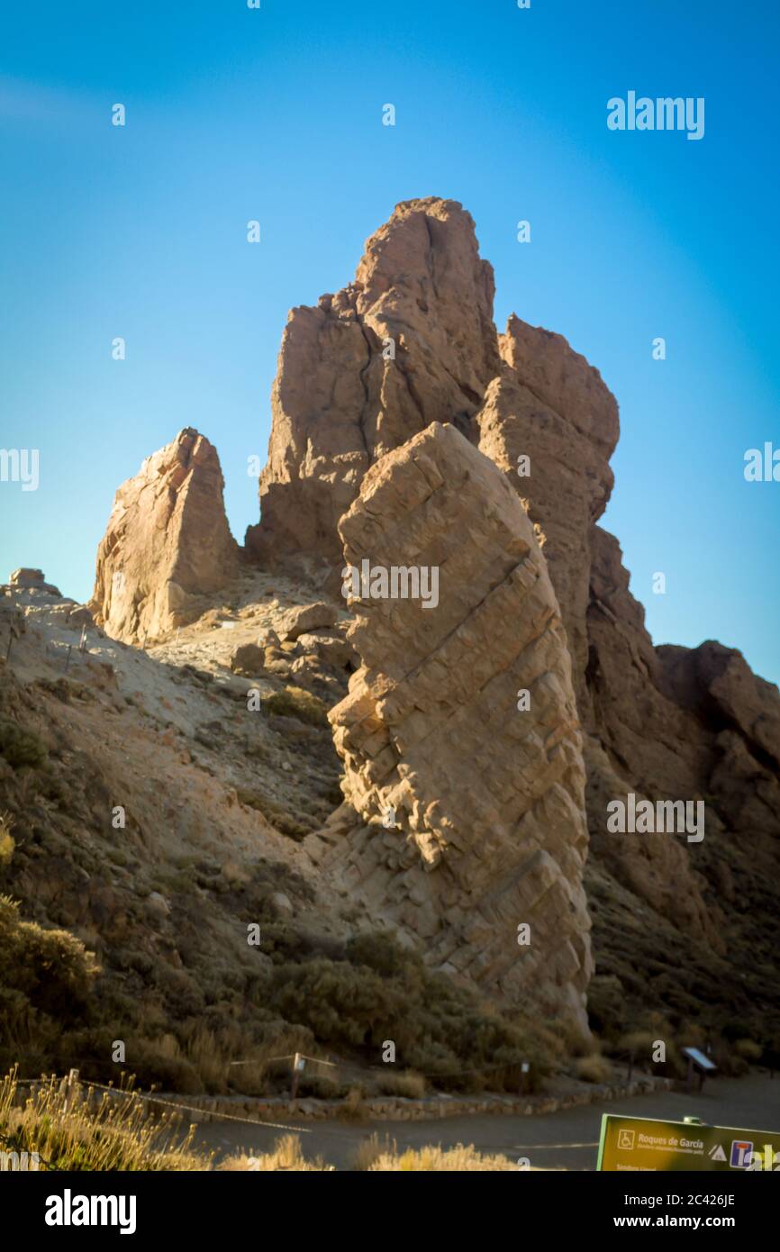 Une grande structure rocheuse dans le désert de ténérife, en espagne contre un ciel bleu clair et lumineux avec la route en premier plan Banque D'Images