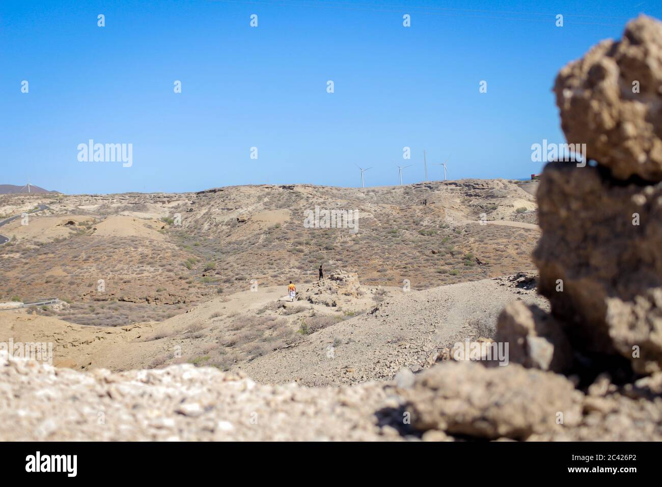 Une chaîne de montagnes sèches à Tenerife, espagne contre un ciel bleu clair en arrière-plan avec une pile de rochers hors de point de vue au premier plan Banque D'Images