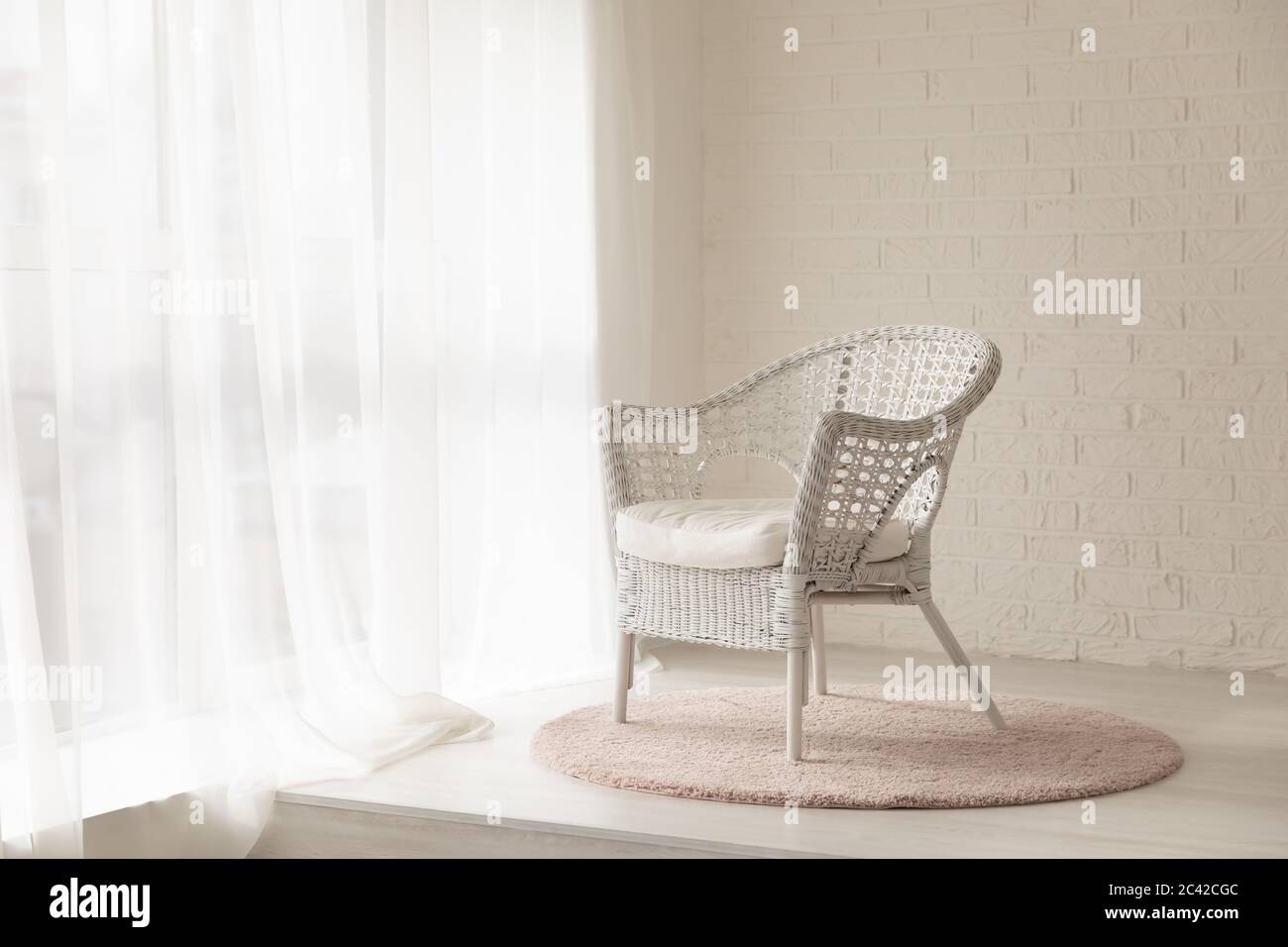 Fauteuil en osier blanc dans une chambre moderne vide avec moquette Banque D'Images