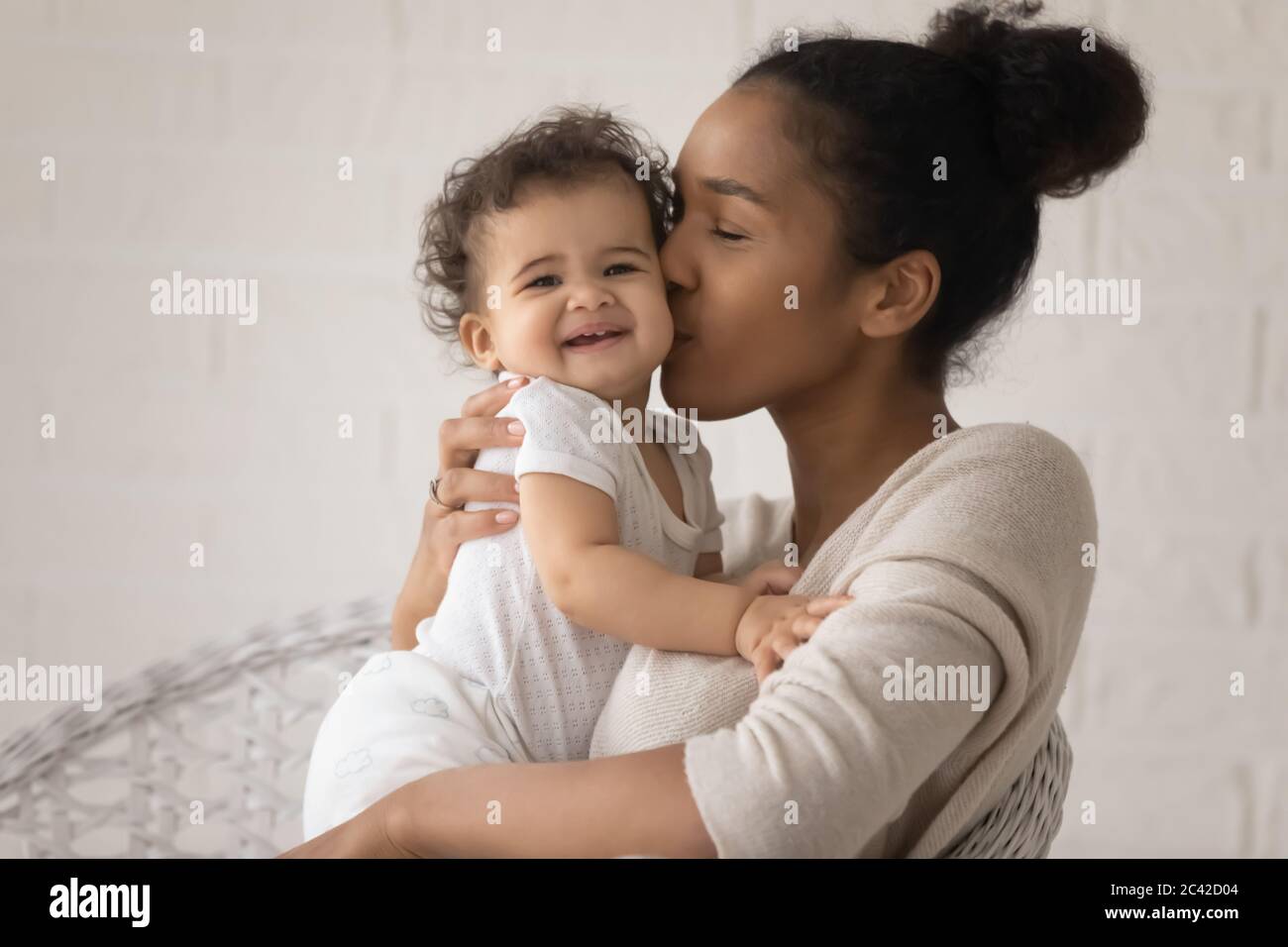 Gros plan amour jeune mère afro-américaine embrassant petite fille Banque D'Images