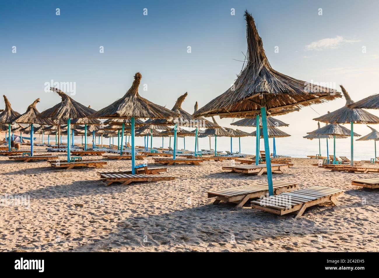 Mer Noire, Roumanie. Parasols en paille sur la plage dans le village de Vama Veche. Banque D'Images