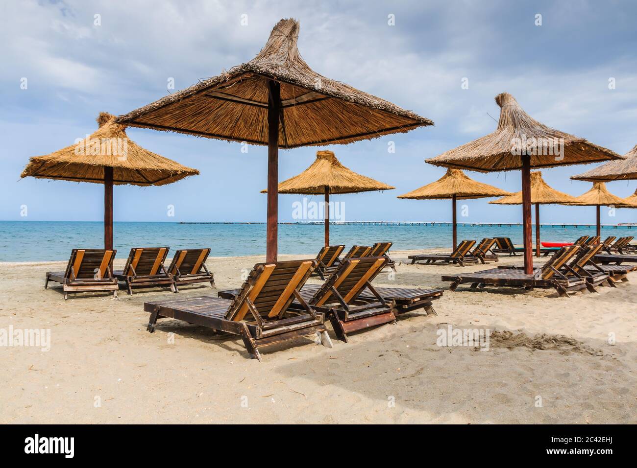 Mer Noire, Roumanie. Parasols en paille sur la plage de Mamaia. Banque D'Images