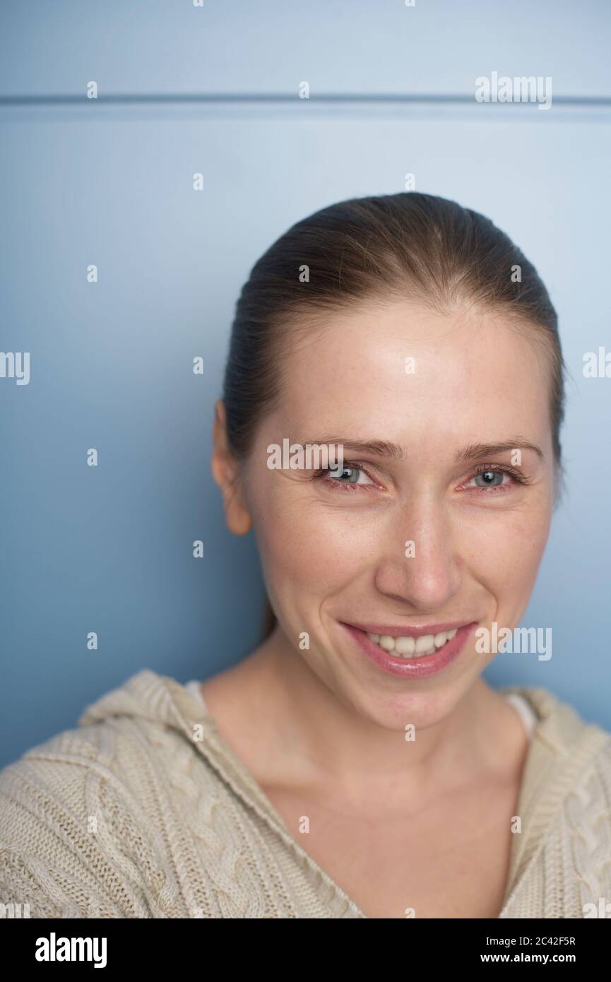 Jeune femme avec des cheveux blond cendré sur fond bleu - portrait - naturel Banque D'Images