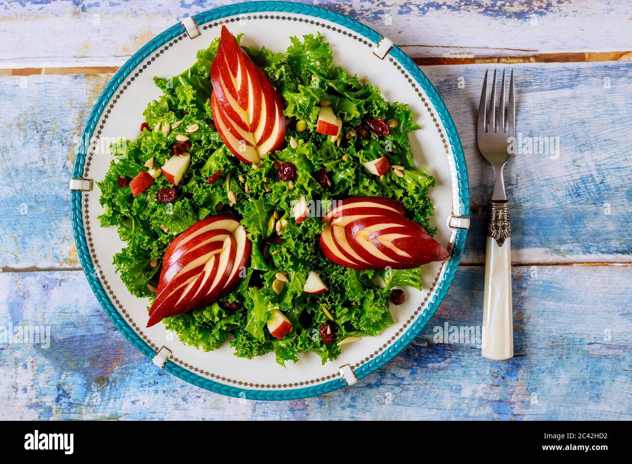 Salade de fête avec chou vert, pomme, canneberge et graines de tournesol sur fond de bois bleu. Banque D'Images