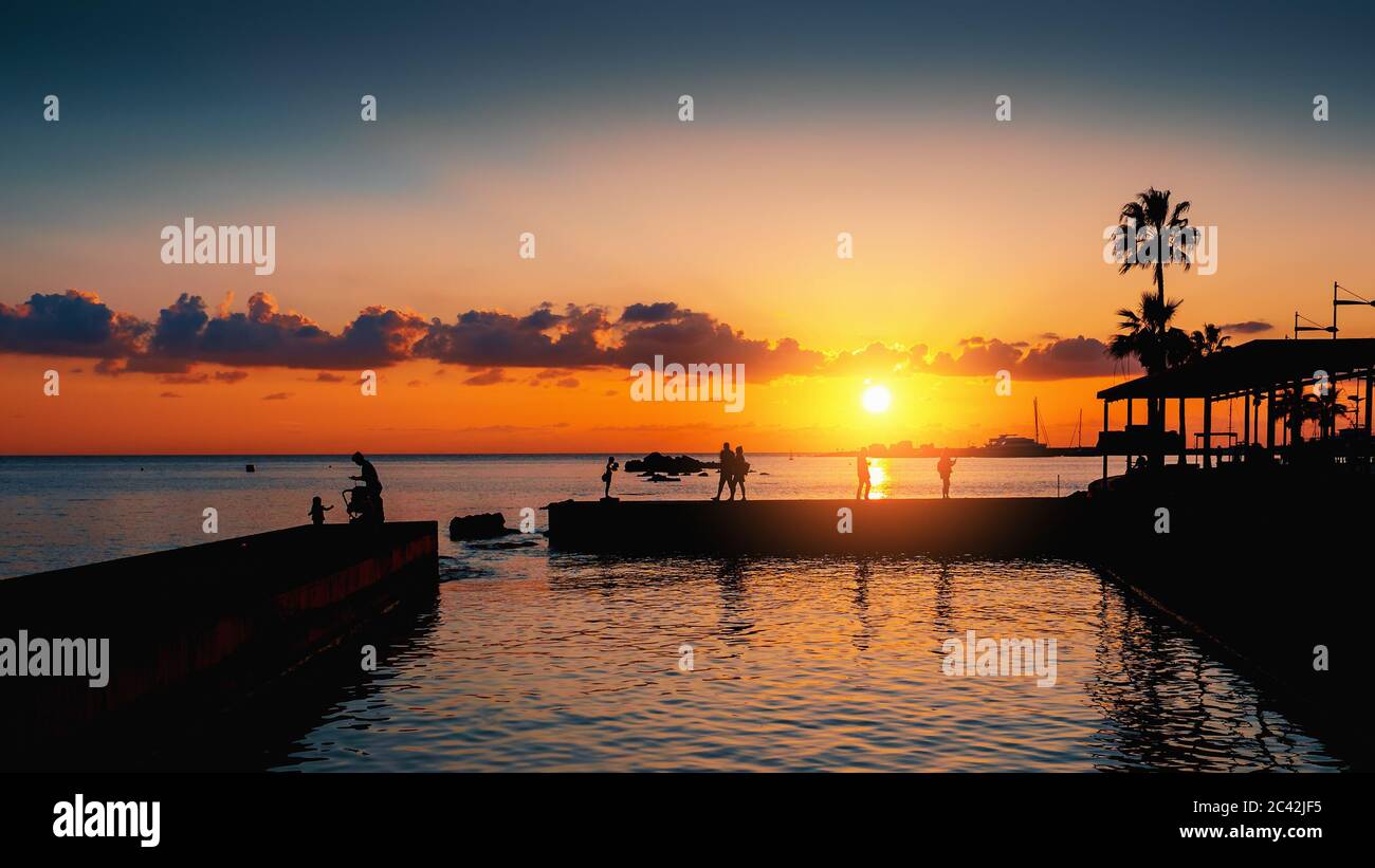 Coucher de soleil spectaculaire sur la mer méditerranée et silhouette de jetée avec des touristes méconnus, ambiance romantique. Banque D'Images