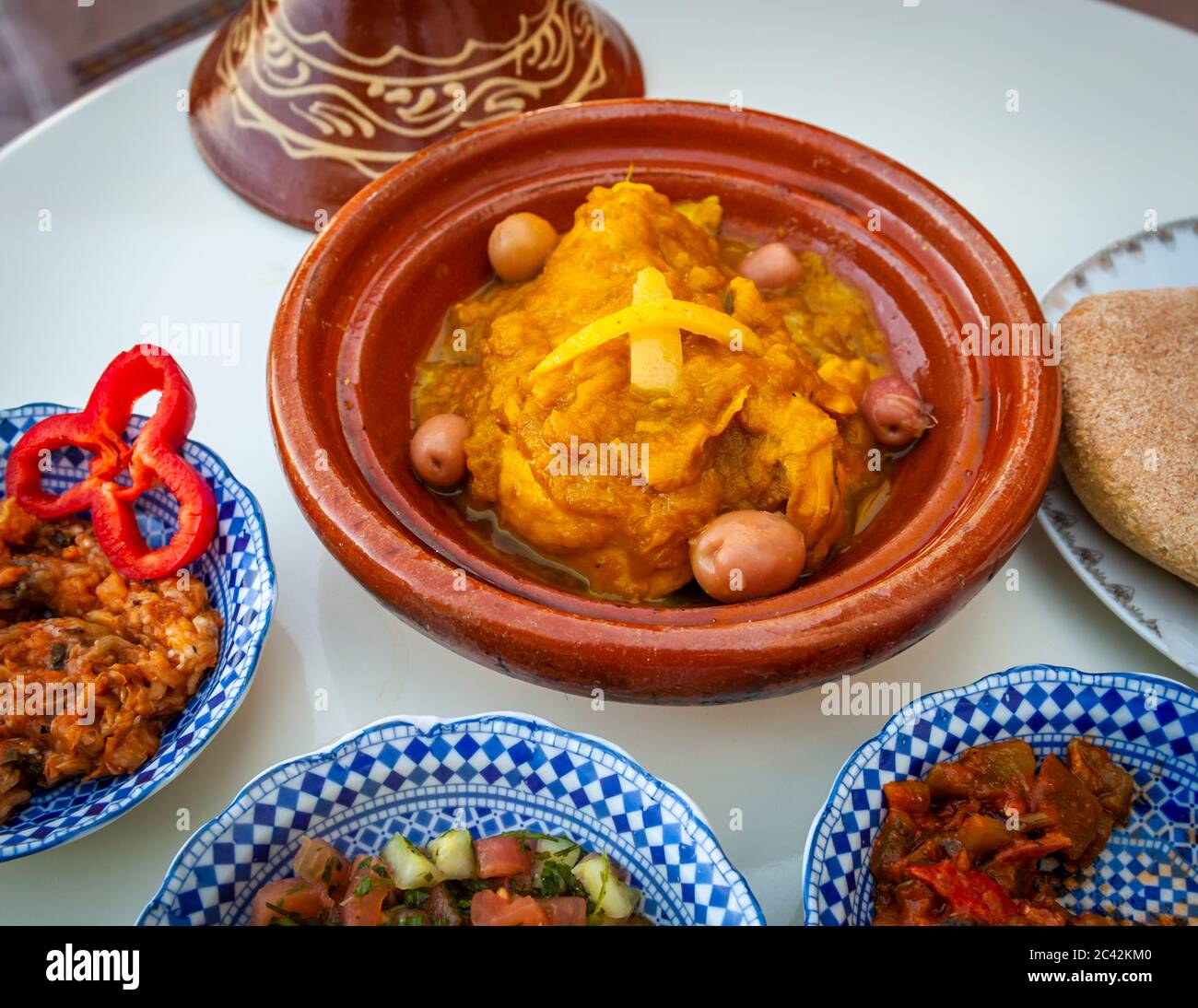 Des spécialités marocaines typiques, comme le poulet au citron, sont préparées dans le tajine d'argile Banque D'Images