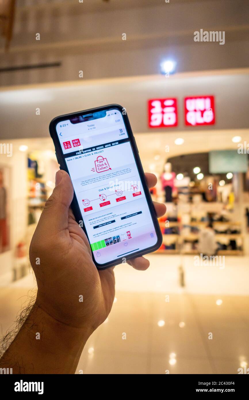 Main d'un homme tenant un iphone X avec des applications uniqlo en face du  magasin Uniqlo. Uniqlo apps est parfait pour ceux qui préfèrent le shopping  en ligne Photo Stock - Alamy