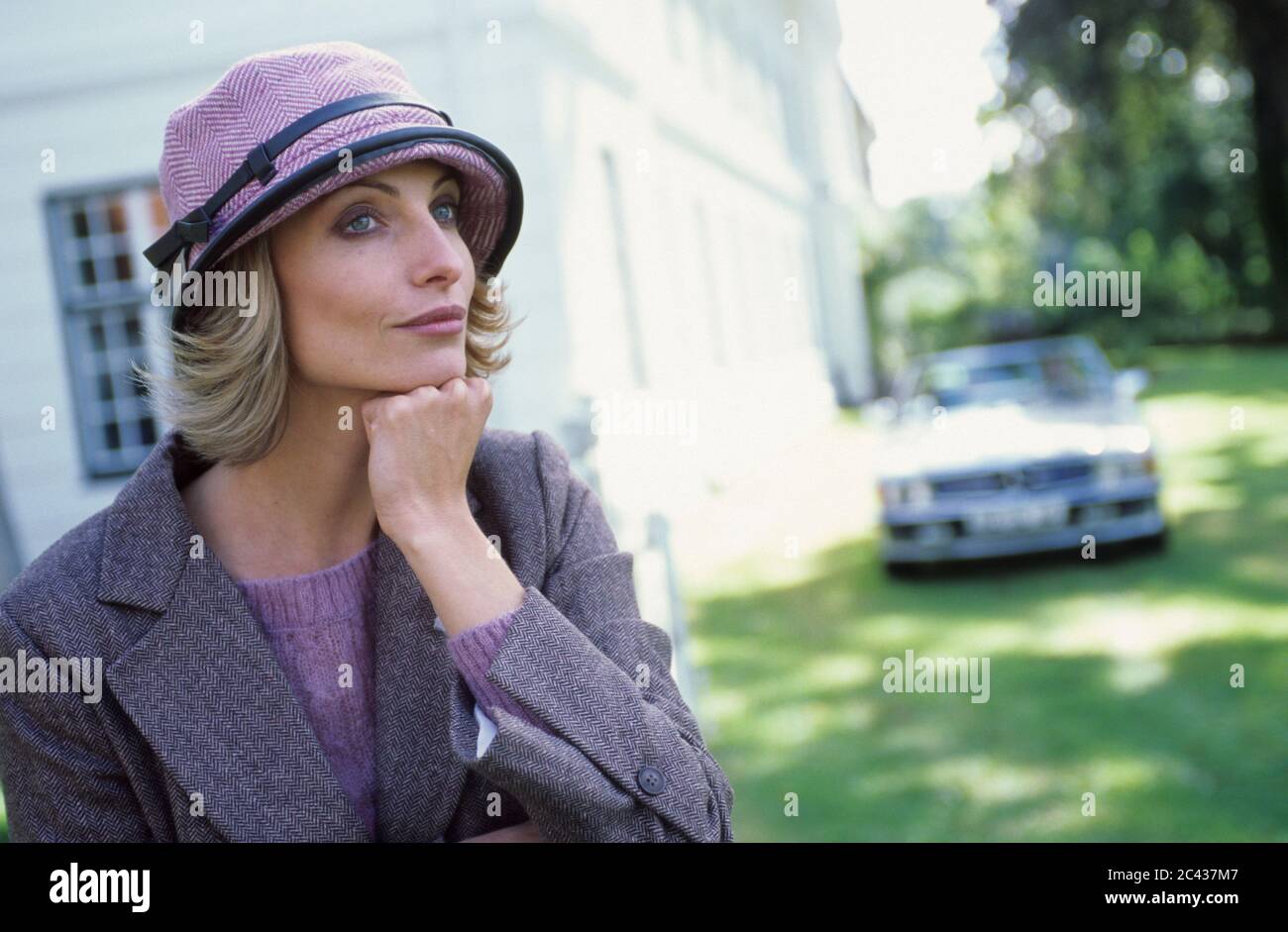 Femme blonde dans un chapeau devant un manoir - Fortune - aristocratie - haute société Banque D'Images