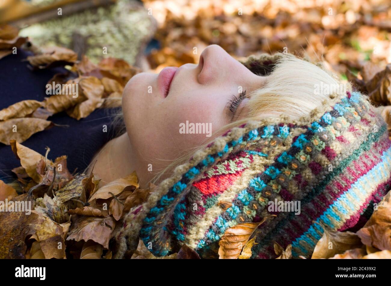 La jeune femme se trouve dans les feuilles d'automne, Flaucher, Munich, Bavière, Allemagne Banque D'Images