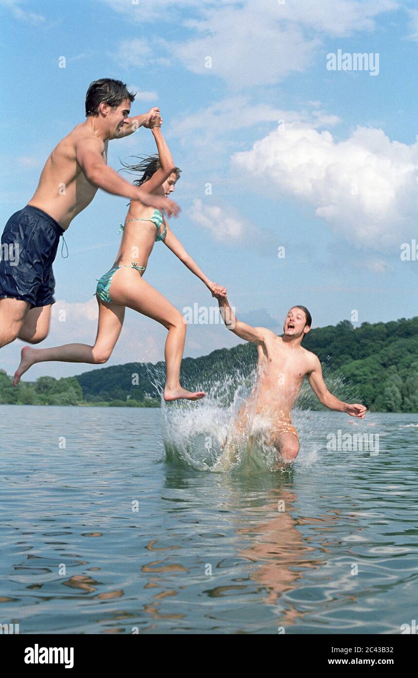 Trois jeunes sautent dans l'eau Banque D'Images