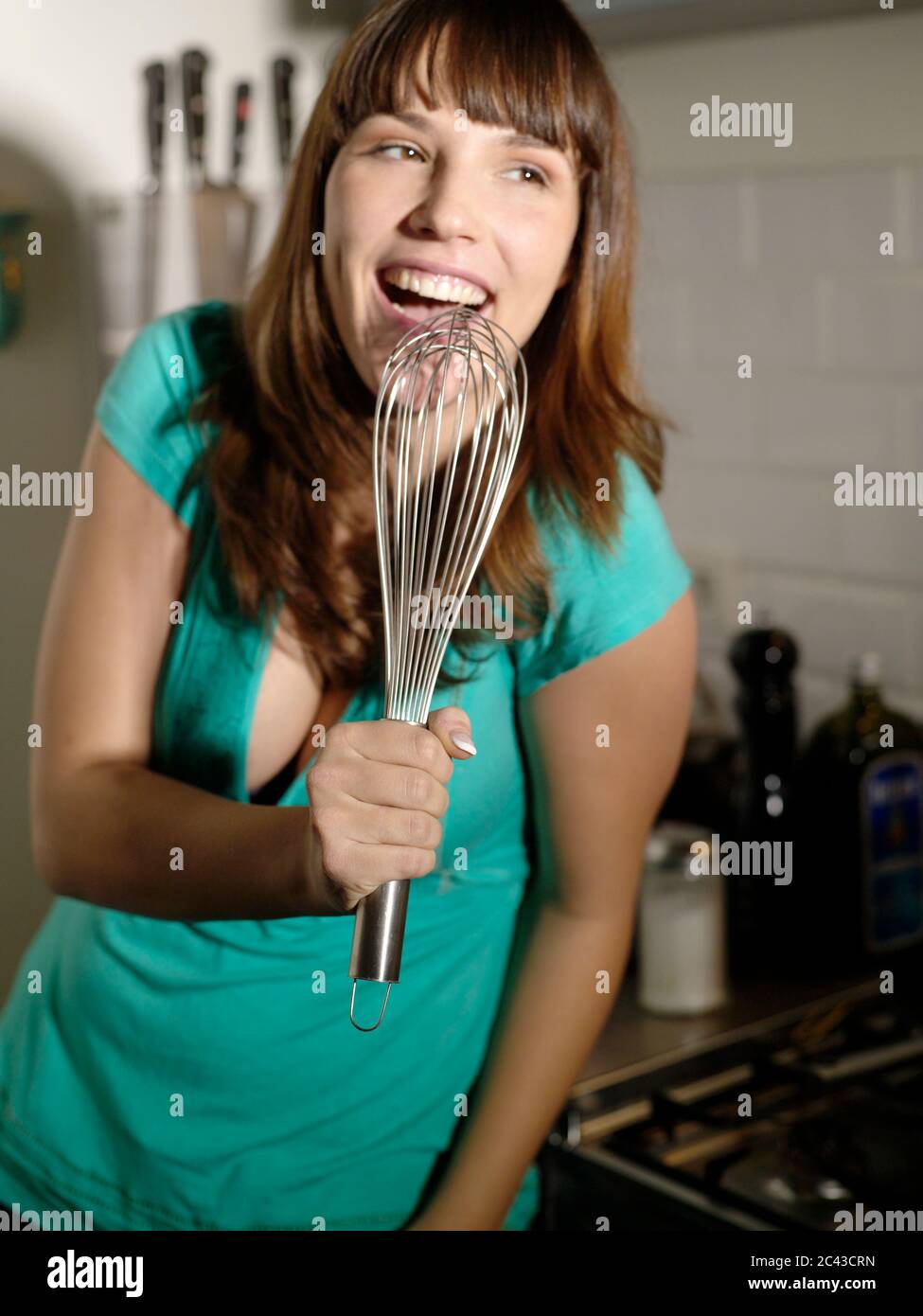 Jeune femme joyeuse dans la cuisine, Berlin, Allemagne Banque D'Images