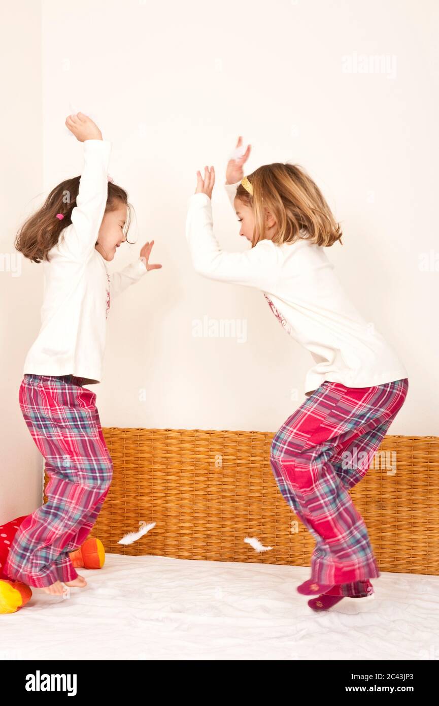 Deux filles sautent sur le lit, Anzing, Bavière, Allemagne Banque D'Images