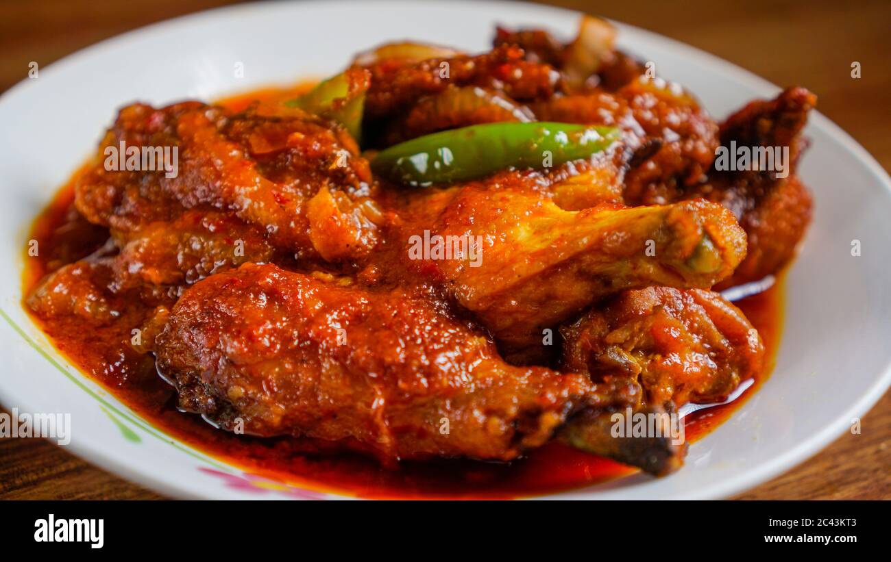 Ayam masak merah est un plat traditionnel malaisien. Cela signifie littéralement « cuit-rouge » de poulet en anglais. C'est une cocotte de morceaux de poulet en c séché Banque D'Images