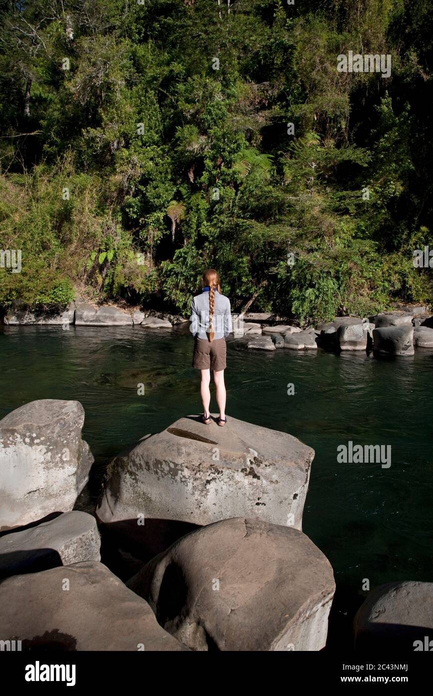 Femme se tient sur un rocher au bord d'une rivière, Patagonie, Chili Banque D'Images