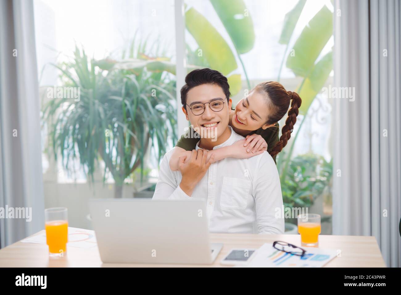 Couple affectueux. Homme ravi exprimant sa positivité tout en travaillant à la maison Banque D'Images