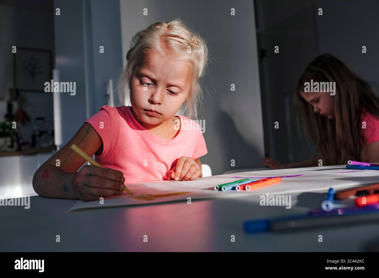Jolie fille colorant sur papier à la maison Banque D'Images