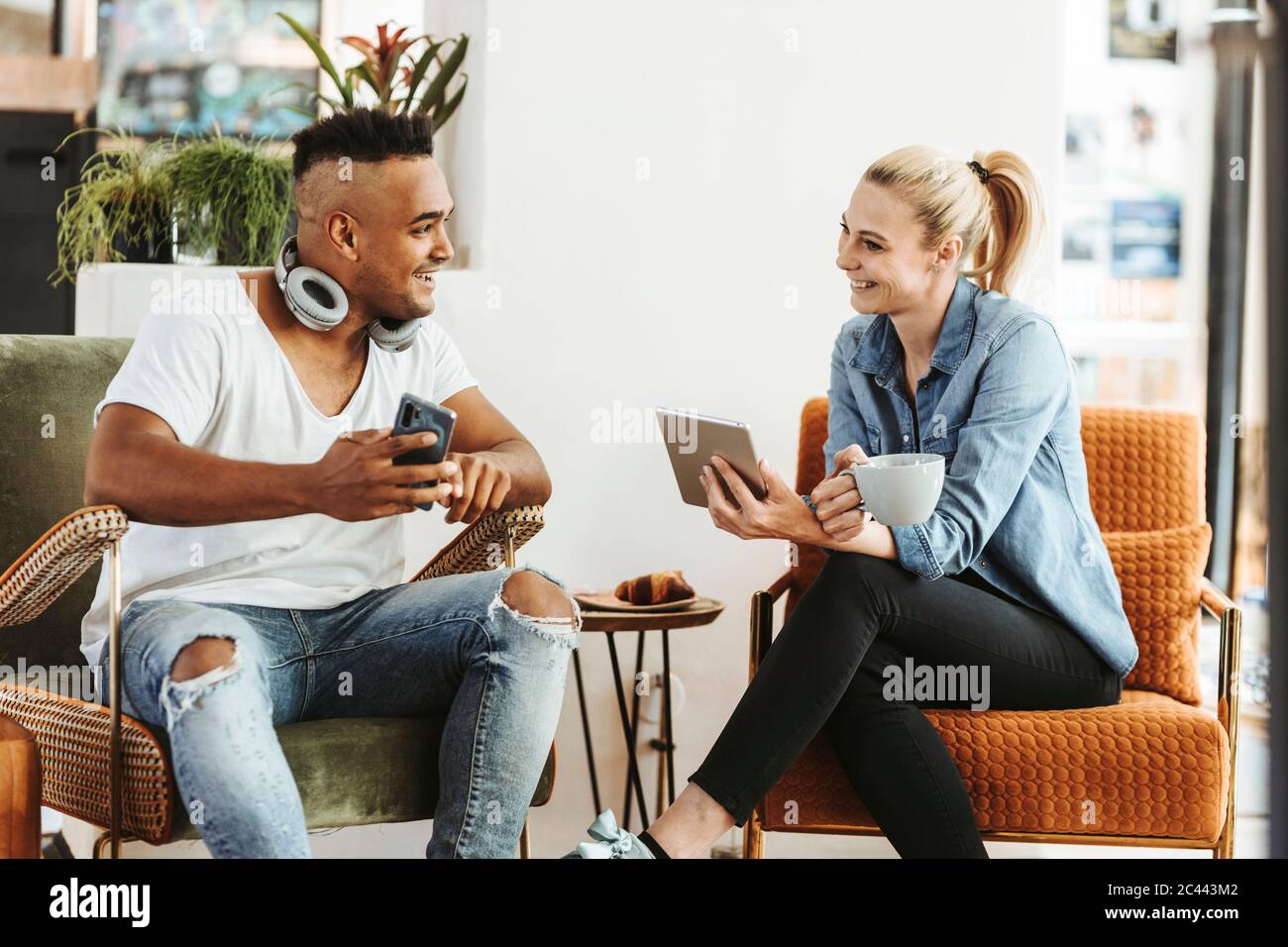 Couple utilisant des appareils électroniques à la maison Banque D'Images