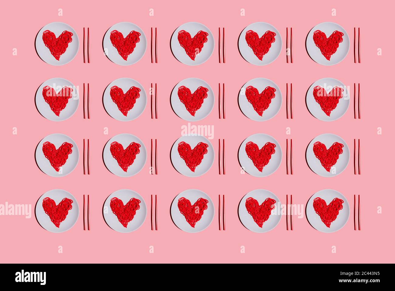 Motif de plaques avec spaghetti en forme de cœur de couleur rouge sur fond rose Banque D'Images
