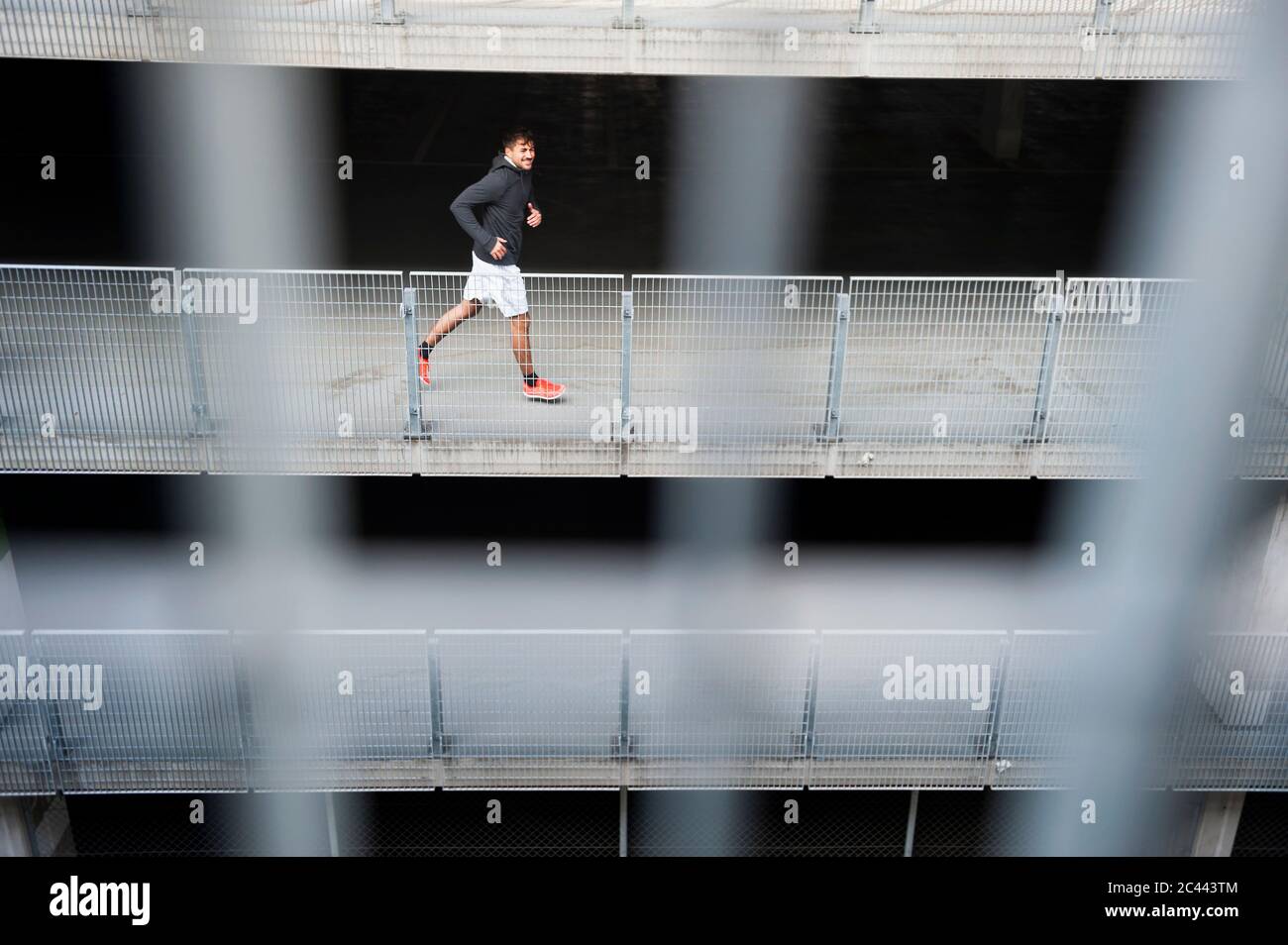 Jeune homme qui court dans un parking Banque D'Images