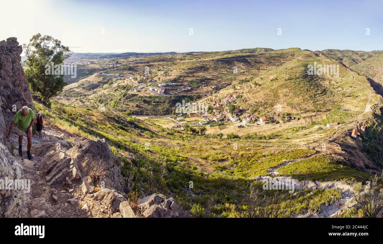 Espagne, Canaries, La Gomera, deux randonneurs ordre croissant avec la Montagne de la Table Mountain Village en arrière-plan Banque D'Images