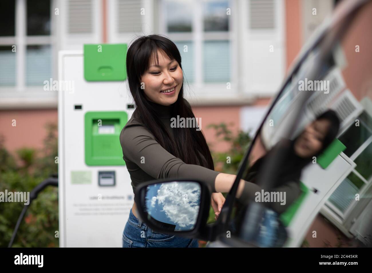 Carshing, femme louant une voiture électrique Banque D'Images