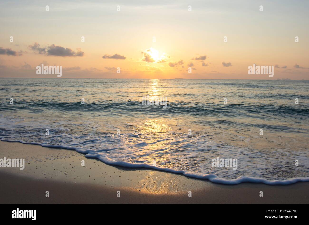 Vagues de mer qui frappent la plage nuages de fond et lumière dorée du lever du soleil le matin sur le ciel à Thung Wua Laen Beach , Chumphon , Thaïlande. Banque D'Images