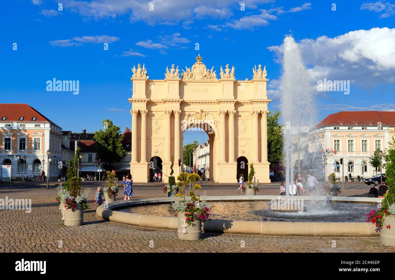 Potsdam, Allemagne. 23 juin 2020. La fontaine de Luisenplatz sur fond de porte de Brandebourg à la lumière du soleil couchant. La porte, modelée sur une arche triomphale romaine à l'extrémité ouest de la Brandenburger Straße, a été conçue par ordre de Frédéric le Grand entre 1770 et 1771. À cette fin, l'ancienne porte simple a été démolie après la fin de la guerre de sept ans. L'architecte Carl von Gontard a conçu le côté de la ville, tandis que son étudiant Georg Christian Unger a conçu le côté faisant face au pays. Credit: Soeren Stache/dpa-Zentralbild/ZB/dpa/Alay Live News Banque D'Images