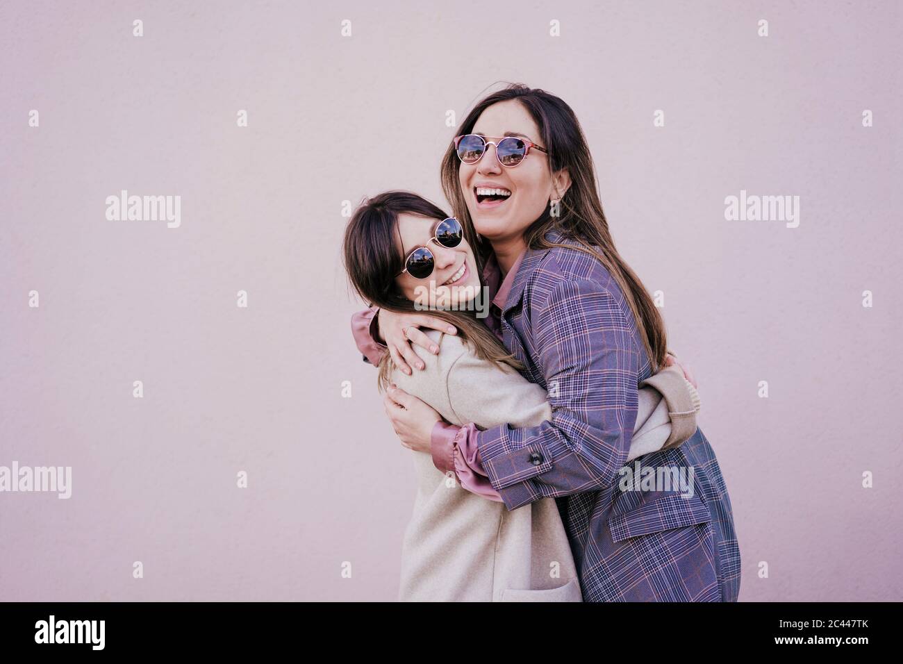 Portrait de deux jeunes femmes heureux qui s'embrasent Banque D'Images
