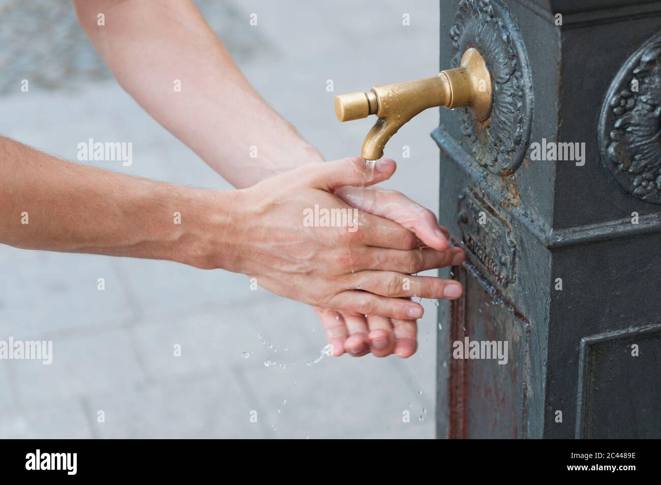 Homme se lavant les mains à la fontaine, Sardaigne, Italie Banque D'Images