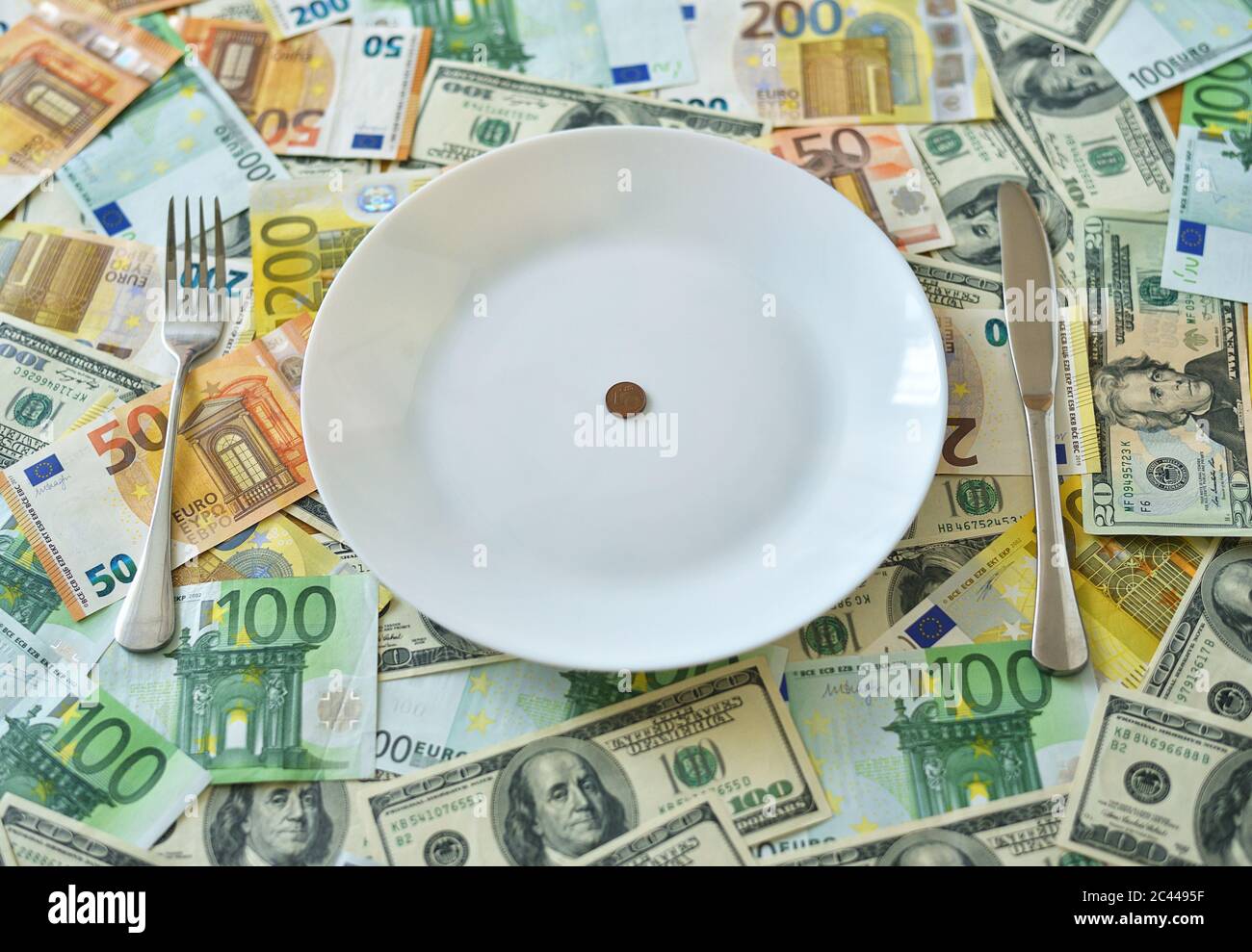 Pièce de monnaie euro cent sur une assiette blanche avec fourchette et couteau Banque D'Images